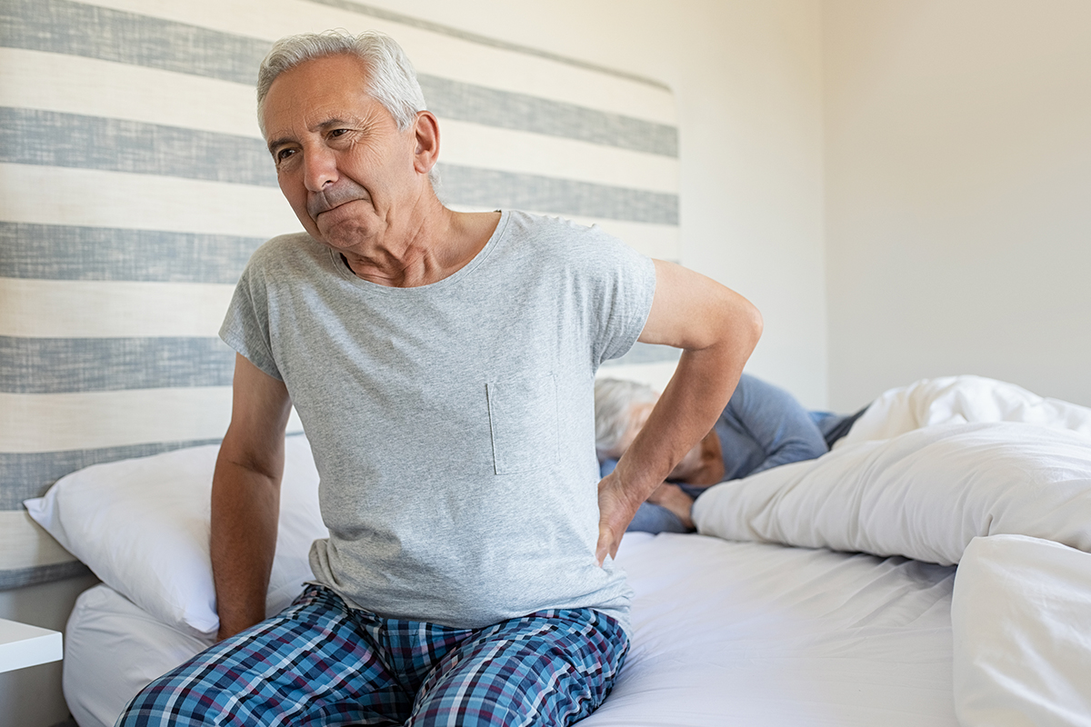 elderly man in bed before back pain treatment in Irving and Fort Worth
